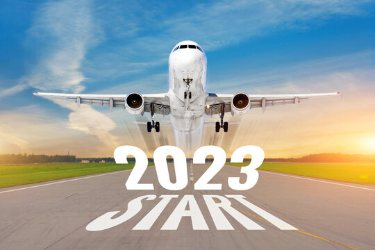 Inscription on the runway start 2023 surface of the airport road line rapidly taking off aircraft. Concept of travel in the new year, holidays.