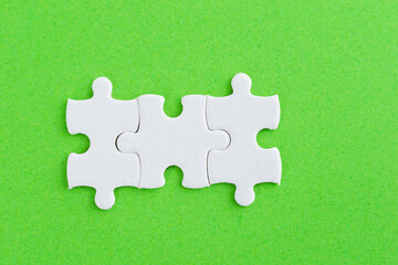 Three puzzle pieces on green background