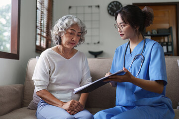 Fototapeta premium Asian youthful nurse caring for patients or the elderly at home. nursing at home concept