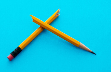 Broken pencil on blue background