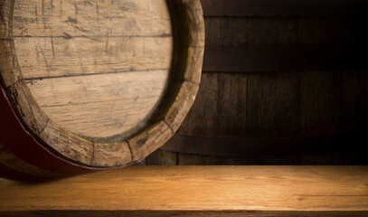 Excellent red wine bottles, wineglass, barrel and corkscrew on a rustic wooden table: traditional winemaking and wine tasting concept. High quality photo