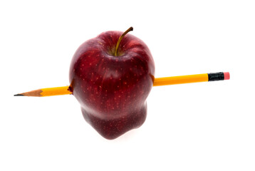 Yellow pencil through an apple on white background