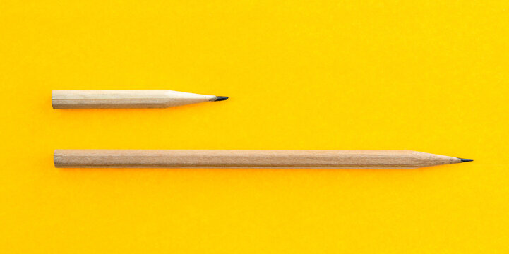 Long and short pencils on yellow background