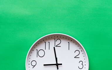 Fototapeta na wymiar Closeup single clock hanging on green wall
