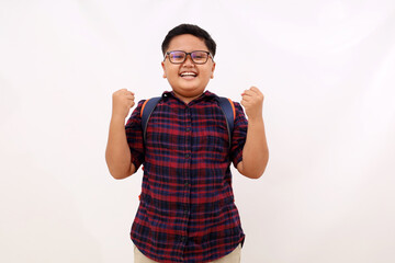 Fototapeta premium Happy asian school boy with eyeglasses standing with clenched hand. Success concept. Isolated on white background