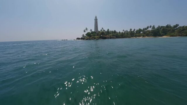 a lighthouse in the middle of a tropical jungle FPV drone view