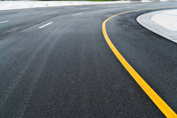 Fototapeta na wymiar Asphalt road with white stripes and yellow lines