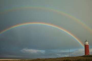 rainbow above the sea with the lighthouse of Texel on the right