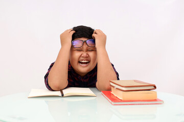 Stressed asian school boy holding his head while doing his homework. Isolated on white background