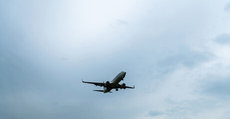Fototapeta na wymiar Background of airplane flying in overcast sky