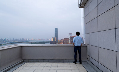 Businessman standing on the rooftop with hands in pocket