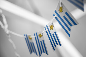 A garland of Uruguay national flags on an abstract blurred background