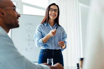 Happy business woman discussing with her team in a meeting