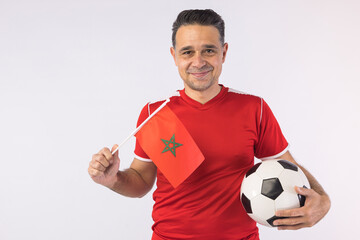 Man wearing a red Moroccan shirt, holding a Moroccan flag. Sport, world cup.