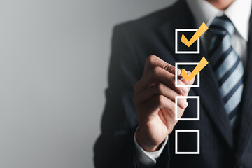 Checklist concept. Businessman checking mark on checkboxes, copy space.
