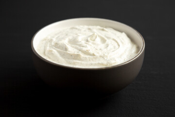 Homemade Ranch Dressing in a Bowl on a black background, side view.