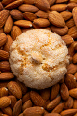 Top vertical view of a pardulas biscuit with almond as a background