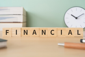 FINANCIALと書かれたブロックが置かれたデスク
