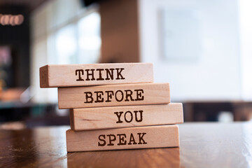 Wooden blocks with words 'Think Before You Speak'.