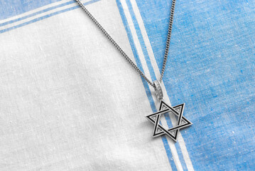 Star of David Necklaces and Pendants, Magen David on white-blue fabric.