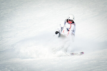 Female skier extreme skiing downhill pass side super fast in snowy conditions to gondola with mountains background. Georgia travel destination caucasus