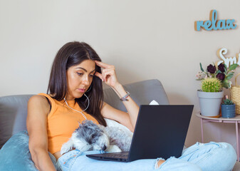 Beautiful Young   Woman Looking at her Laptop .Woman working from home with her dog 