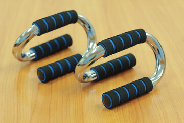 Push up bar grips on wood background, Sport exercise equipment