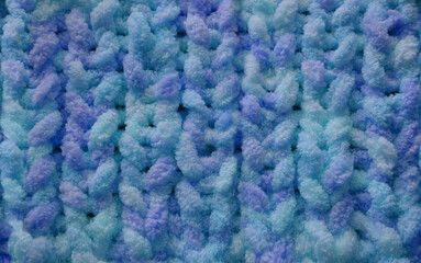 beautiful cozy knitted background for designer, handmade knitting with fluffy terry, light blue, lilac threads, concept hobby knitting, needlework for relaxation, mental health supportive care