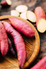 sweet potato tubers on a wooden surface close-up, organic sweet potato