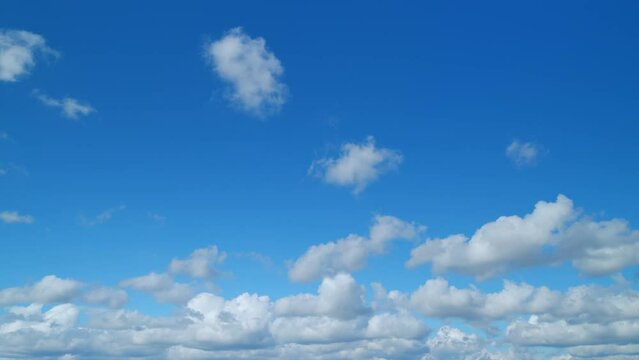 Cloudscape cumulus and cirrus on different layers moving on beautiful bright sunny clear blue sky. Cloudscape moved on daylight horizon. Timelapse.