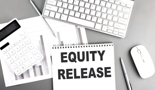 EQUITY RELEASE text written on notebook on grey background with chart and keyboard , business concept