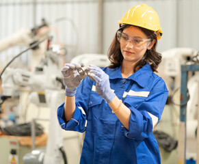 Industrial engineer woman wears safety helmet examining lathe steel in metalwork factory....