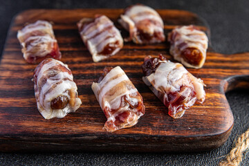 dates in bacon snack smoked meat dry-cured meal food snack on the table copy space food background rustic top view