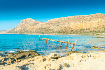 Old rusty jetty on the amazing crystal clear water of Balos Lagoon, Crete,  Greece