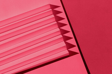 Viva Magenta color of the year 2023. Abstract crimson red color  paper texture. Folded paper with harsh sun shadows, geometric shapes and lines.