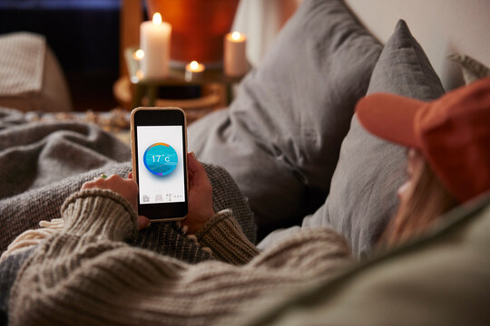 Woman lying in bed and using temperature app