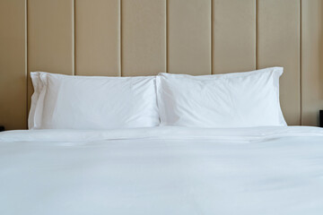 Fototapeta na wymiar White pillows and duvet on a bed