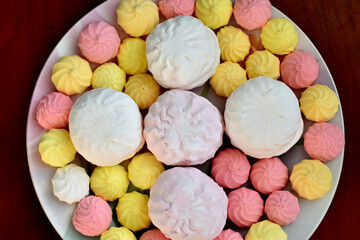 Marshmallows and meringue lie on a round plate.