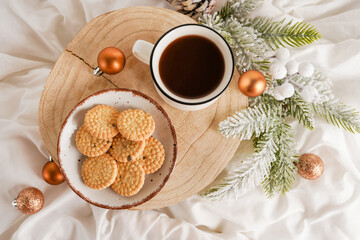 Cup of coffee with cookies on the wood, Christmas decorations on bed
