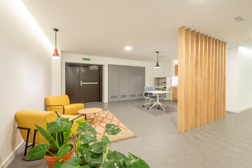 Entrance hall and waiting room of an office with plants and a lattice of wooden strips