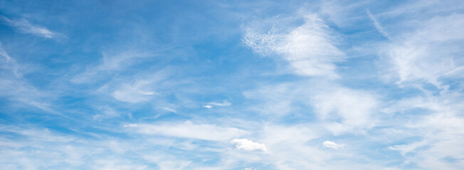 wide sky panorama with feathery clouds on blue background