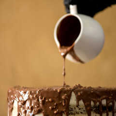 Chocolate icing for the cake. Hot chocolate. Melted milk chocolate. Cake in glaze. Icing dessert. Sauce bowl with chocolate.Cooking sweets. Soft focus. Close-up. Side view. 