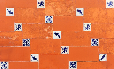 Decorative socle that combines red ceramic tiles and small tiles with blue silhouettes on a white...