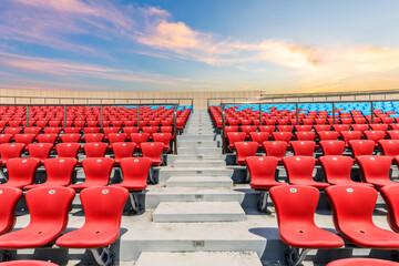 Red seats and beautiful sky clouds in the stadium