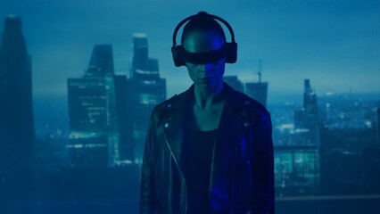 Portrait of cyberpunk girl with a smartphone in a glasses and headphones. Beautiful young woman on the background of city scyscrapers. © Acronym