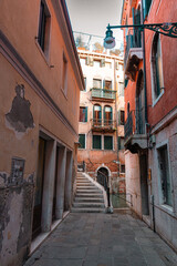 Fototapeta na wymiar Rua estreita de Veneza com uma das pontes passando por um pequeno canal 