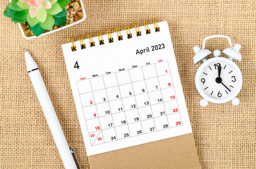 The April 2023 Monthly desk calendar for the organizer to plan 2023 year with alarm clock and pen...