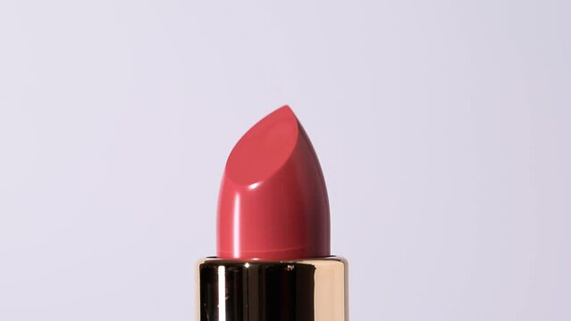 Matte pink female lipstick open and close over white background. Pink lipstick closeup.