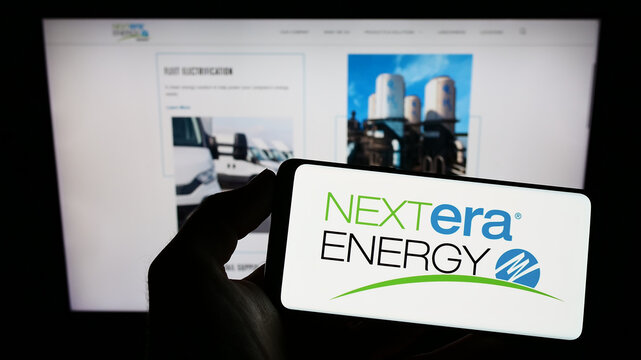 Stuttgart, Germany - 12-01-2022: Person Holding Smartphone With Logo Of US Energy Company NextEra Energy Inc. On Screen In Front Of Website. Focus On Phone Display.