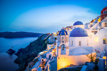 traditional greek village Oia of Santorini, with blue domes of churches and village roofs at night, Greece, toned